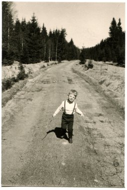 küçük çocuk bir toprak yol çam ormanı ile devam ediyor.