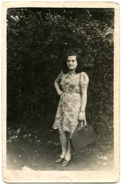 elinde bir çanta ile giysili bir genç kız portresi
