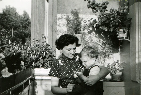 Donna con un bambino tra le braccia seduto sul balcone — Foto Stock