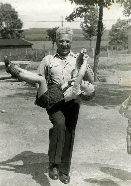 Joyful grandfather carries a grandson — Stock Photo, Image