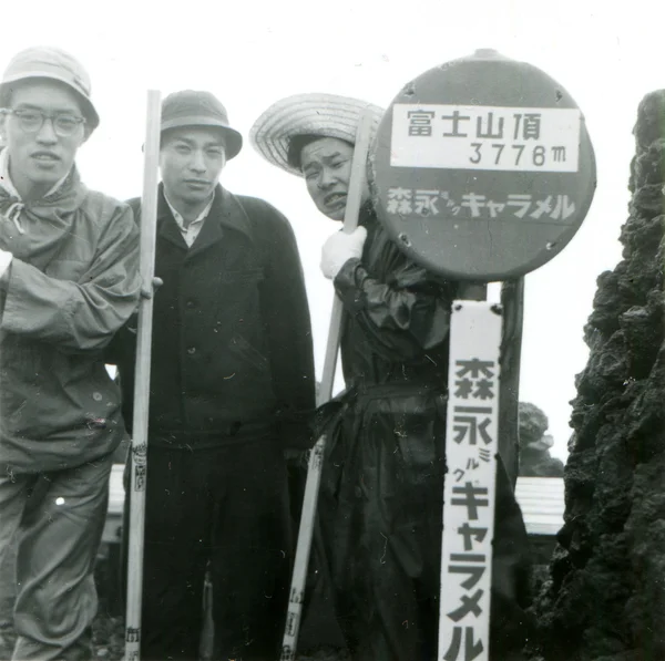 Three young men near a sign with the height of Mount Fuji — Stock Photo, Image