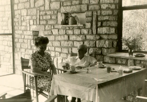 Hombre y mujer tomando té en la terraza con una pared de piedra — Foto de Stock