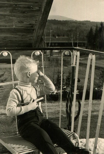 Jongen zittend op een stoel op het balkon — Stockfoto