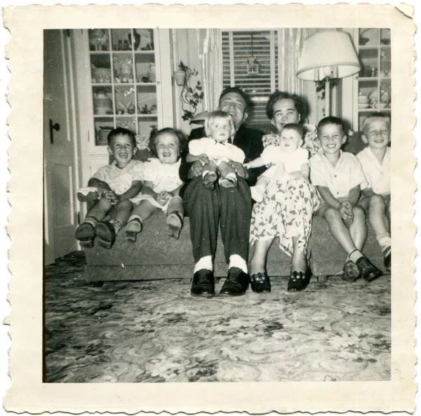 Abuelos sentados en el sofá con seis nietos — Foto de Stock