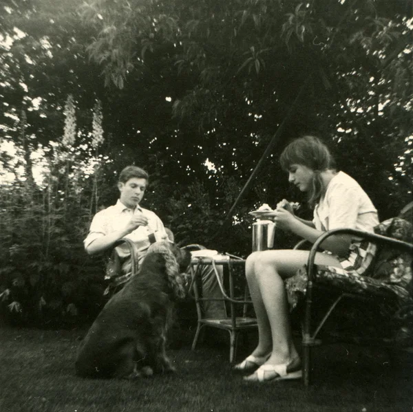 Jeune homme et femme déjeunant dans le jardin — Photo