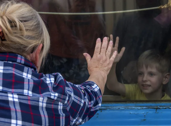 キエフの出発する列車の窓から見て、彼らの子供を持つ人々 — ストック写真
