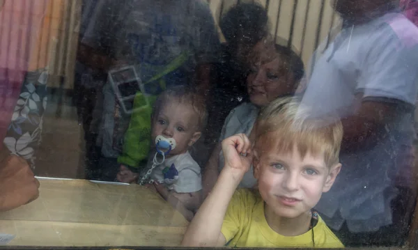 Люди с детьми смотрят в окно поезда, отправляющегося в Киев — стоковое фото