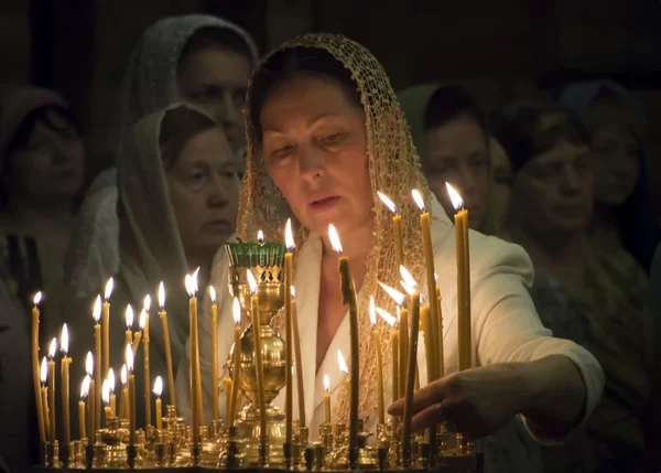 Женщина зажигает памятную свечу — стоковое фото
