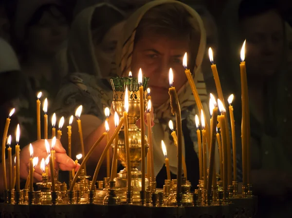 A woman lights a memorial candle — Stock Photo, Image