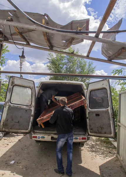 Young men help carry surviving domestic belongings to her parents friends — Stock Photo, Image