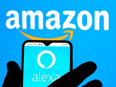 Kiev, Ukraine - January 13, 2022: In this photo illustration, the Amazon Alexa logo is seen displayed on a smartphone screen and Amazon logo in the background. 