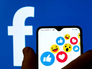 Kiev, Ukrayna - 15 Ocak 2022: Bu resimde Facebook logolarının beğeni ve tepkileri arka planda Facebook logosu olan bir akıllı telefon ekranında gösteriliyor.