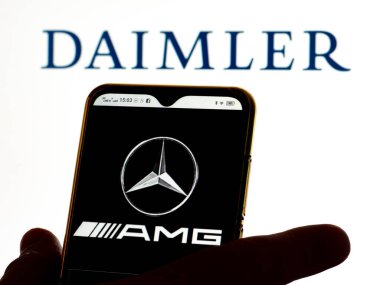 Kiev, Ukrayna - 16 Ocak 2022: Bu resimde, Mercedes-AMG logosu arka planda Daimler AG logosu olan bir akıllı telefon ekranında gösteriliyor.. 