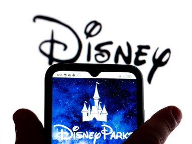 Kiev, Ukrayna - 24 Ocak 2022: Bu fotoğraf illüstrasyonunda, Disney park logosu arka planda Disney logosu olan bir akıllı telefon ekranında gösteriliyor..