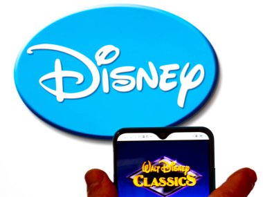 Kiev, Ukrayna - 29 Ocak 2022: Bu resimde, Walt Disney Klasik logosu arka planda Disney logosu olan bir akıllı telefon ekranında gösteriliyor..