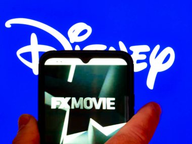 Kiev, Ukrayna - 3 Şubat 2022: Bu resimde, FX Movie logosu arka planda Disney logosu olan bir akıllı telefon ekranında gösteriliyor.