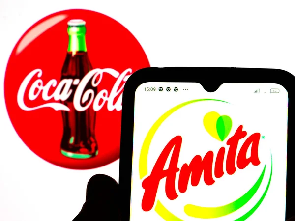 キエフ ウクライナ 2022年2月5日 この写真のイラストでは 背景にコカ コーラ社のロゴが入ったスマートフォンの画面にアメリカ フルーツジュースのロゴが表示されます — ストック写真