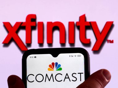 Almanya - 25 Mart 2022: Bu resimde, Comcast Cable (Xfinity) logosu arka planda Xfinity logosu bulunan bir akıllı telefon ekranında gösteriliyor