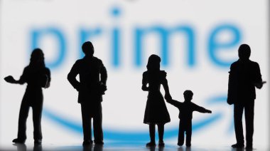 Vilshofen Vilshofen Tuna, Bavyera, Almanya - 1 Mayıs 2022: Akıllı telefondaki bulanık Amazon Prime logosu önünde duran minyatür figürler