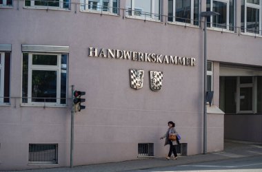 Passau, Bavyera, Almanya - 3 Mayıs 2022: Bir kadın El Sanatları Odası 'nın önünden geçiyor (Handwerkskammer)