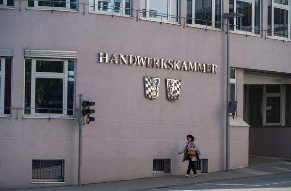 Passau, Bavyera, Almanya - 3 Mayıs 2022: Bir kadın El Sanatları Odası 'nın önünden geçiyor (Handwerkskammer)