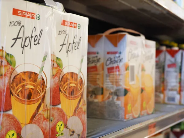 Wels, , Ausatria - August 4, 2022: Packets with 100% apple juice on a shelf in a Spar supermarket