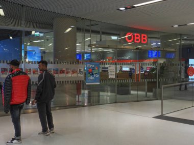 Salzburg, Ausatria - August 5, 2022: Passengers stand near the entrance to the office of the Austrian Railways at Salzburg railway station