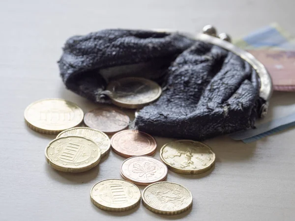 硬币从装有两个10欧元和20欧元钞票的破包里流出 — 图库照片