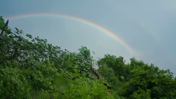 Regenbogen über dem Hausdach und den Bäumen — Stockvideo