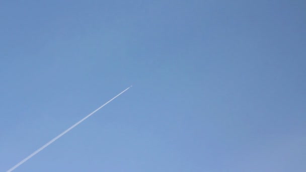 Létající letadlo s stezka v modré obloze — Stock video