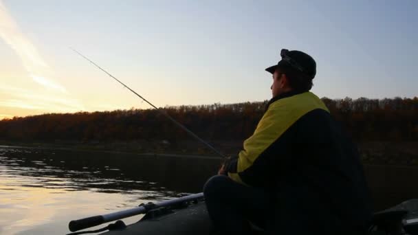 El hombre pesca con spinning al atardecer — Vídeos de Stock