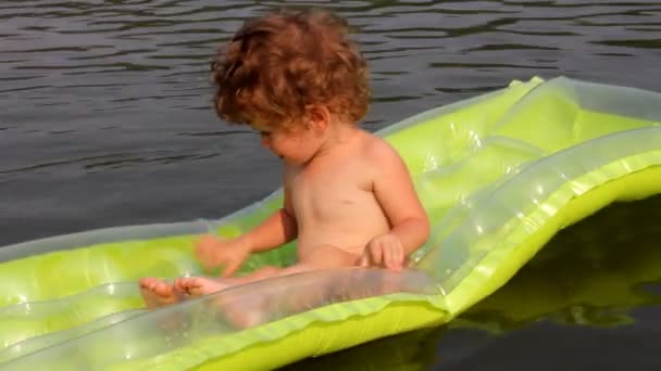Детское купание в реке на надувном матрасе — стоковое видео