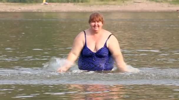 Kvinna med övervikt bad i floden - slow motion — Stockvideo
