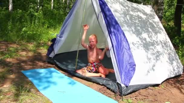 Pojke nära camping tält i skogen — Stockvideo