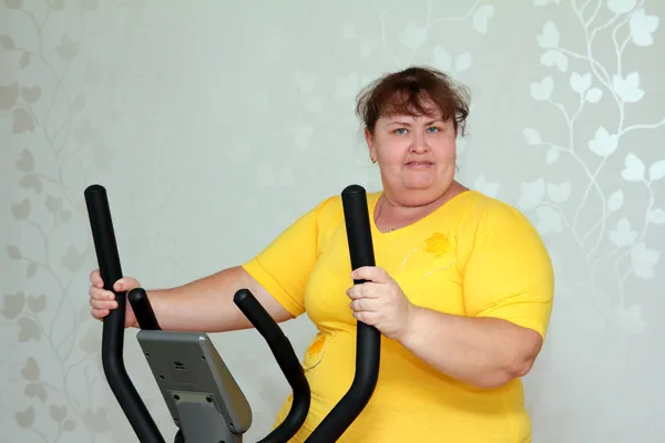 Übergewichtige Frau trainiert auf Trainer — Stockfoto