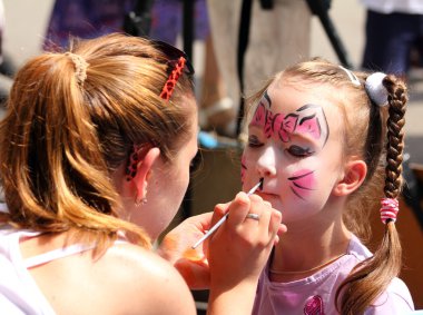 artist paints on face of little girl clipart