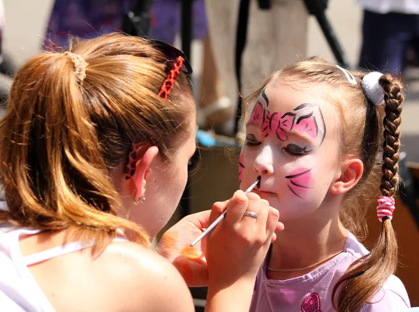 Pinturas de artista en la cara de niña — Foto de Stock