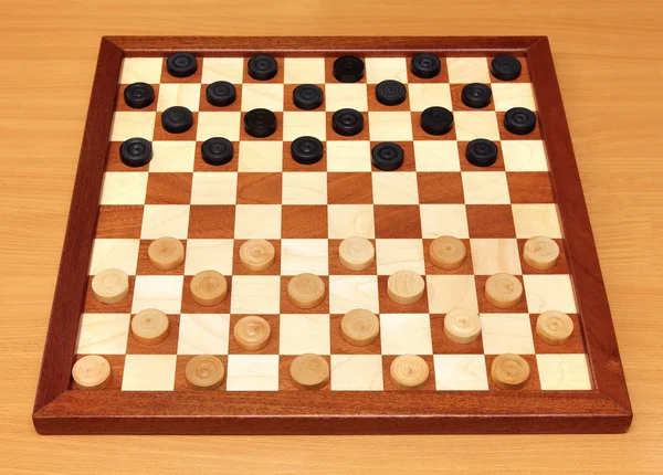 Шахівниця з шашками, розташованими — стокове фото