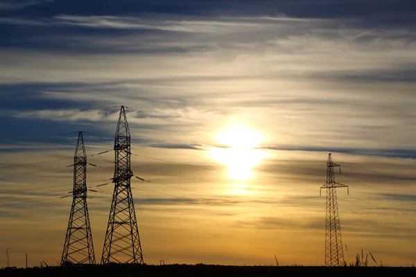 Mâts électriques au coucher du soleil — Photo