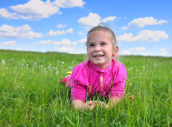 Happy little girl lying on grass — Stock Photo, Image