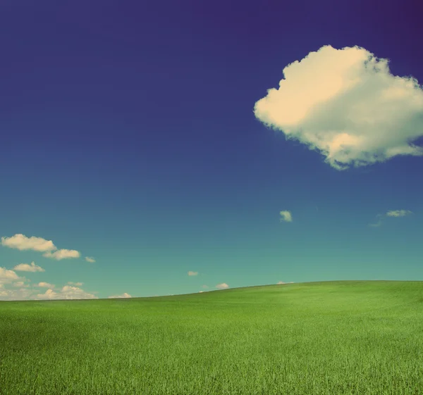 Colina verde bajo el cielo azul - estilo retro vintage —  Fotos de Stock