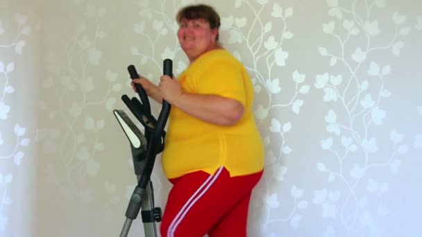 Übergewichtige Frau trainiert auf Trainer-Ellipsoid — Stockvideo