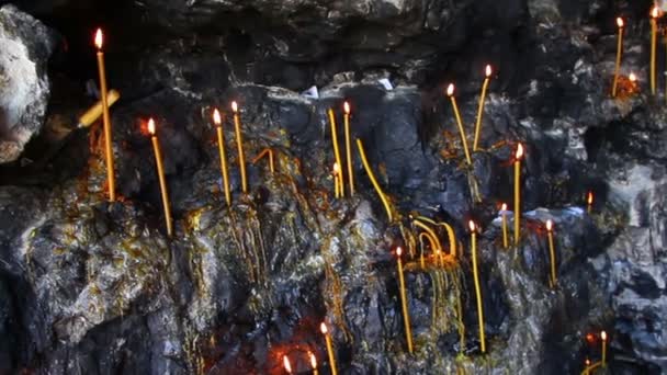 Christelijke heilige plaats - kaarsen in grot — Stockvideo