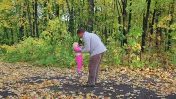 Padre jugando con el bebé en el parque de otoño — Vídeos de Stock