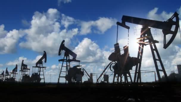 Working oil pumps silhouette against timelapse clouds — Stock Video