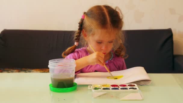 Маленькая девочка рисует краски — стоковое видео