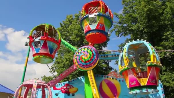 Los niños montan en el carrusel en el parque — Vídeo de stock