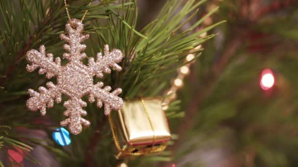 Dekorative Schneeflocke am Weihnachtsbaum mit blinkenden Girlanden geschmückt — Stockvideo