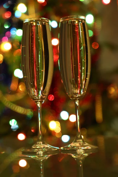 Bicchieri con champagne contro le luci festive — Foto Stock