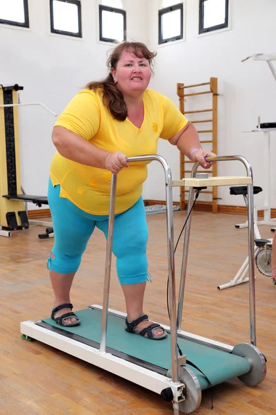 Mulher com excesso de peso correndo na esteira treinador — Fotografia de Stock